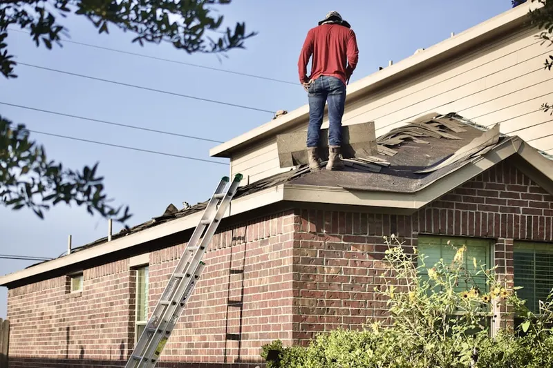 Professional roofer working on a residential roof in Country Club Acres